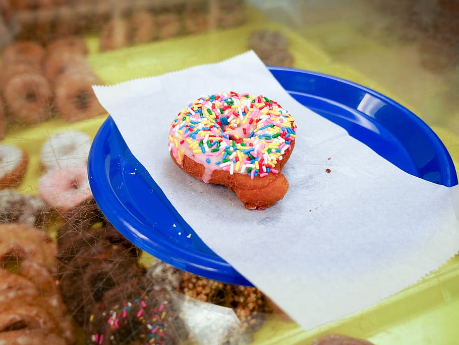 cake donut, strawberry icing, sprinkles, sitting, blue, plate., bakery, breakfast, calories, chocolate