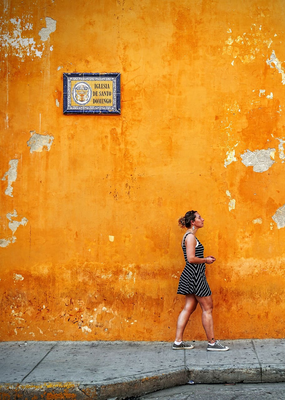 people, woman, street, orange, color, wall, sidewalk, frame, travel, full length
