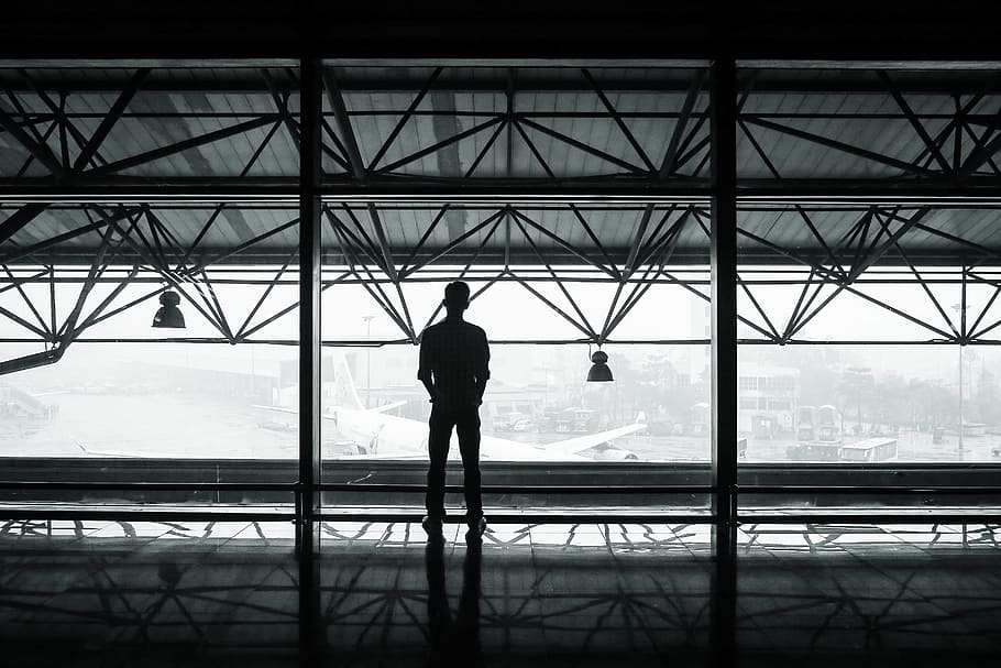 airport, airplanes, hanger, terminal, window, beams, lights, man, shadow, black and white