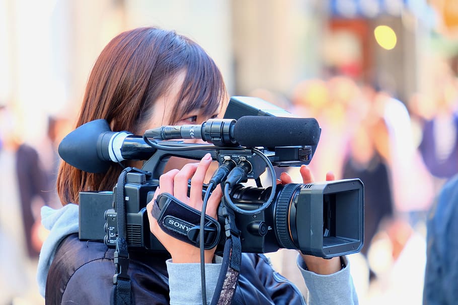 female, cameraman, shooting, video recording, street, one person, focus on foreground, photography themes, portrait, camera - photographic equipment