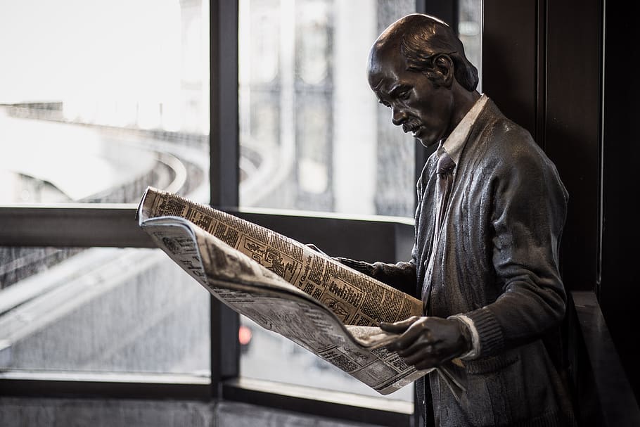 statue, public art, newspaper, read bronze, detroit, station, one person, indoors, real people, side view