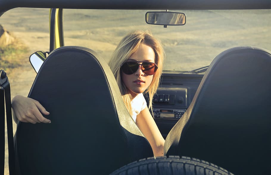 Joven, mujer, gafas de sol, mirando, parte trasera, coche, sentado, asiento de pasajero, 25-30 años, hermosa