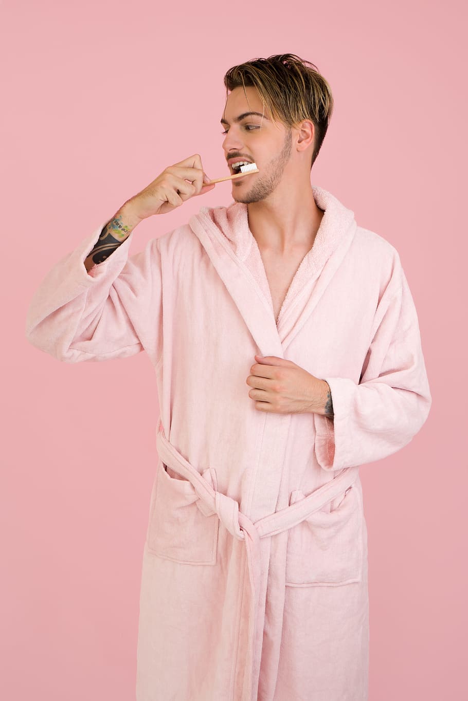 bathrobe, morning, brushing teeth, man, male, handsome man, pink, colored background, studio shot, one person