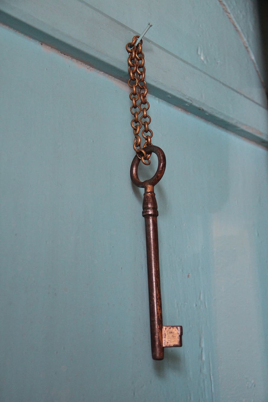 key, the key on the door, key chain, metal, close-up, indoors, chain, hanging, safety, wood - material