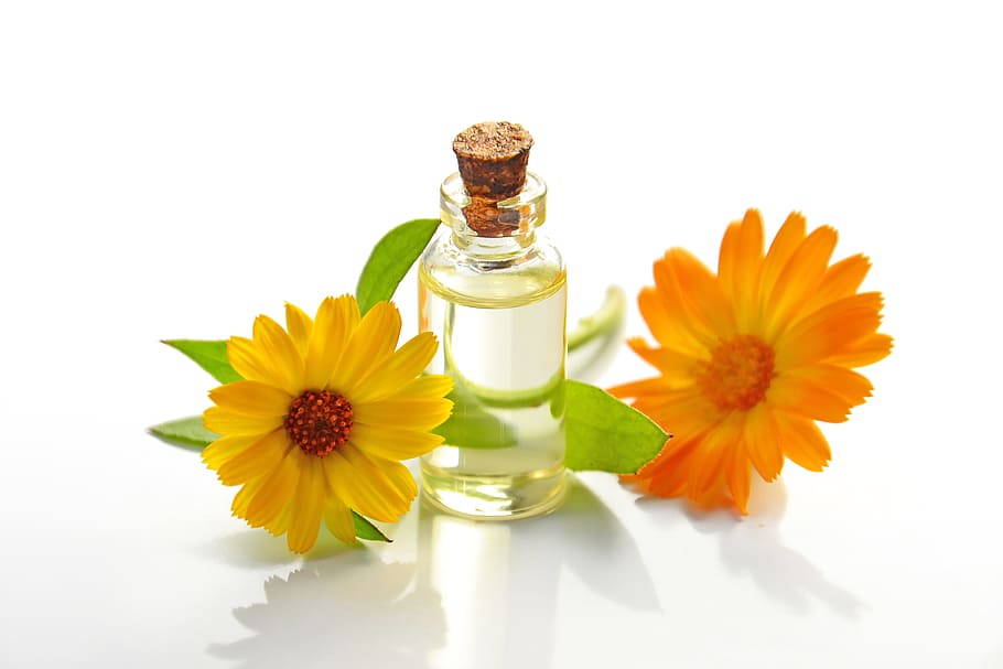 aceite esencial, aceite cosmético, spa, caléndula, naranja, amarillo, pétalos, botella de vidrio, producto natural, aromaterapia
