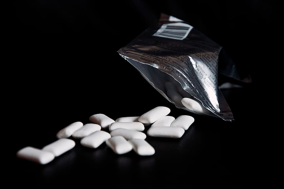 chewing gum, table, scattered, packaging, silver, black background, shiny, studio shot, healthcare and medicine, indoors