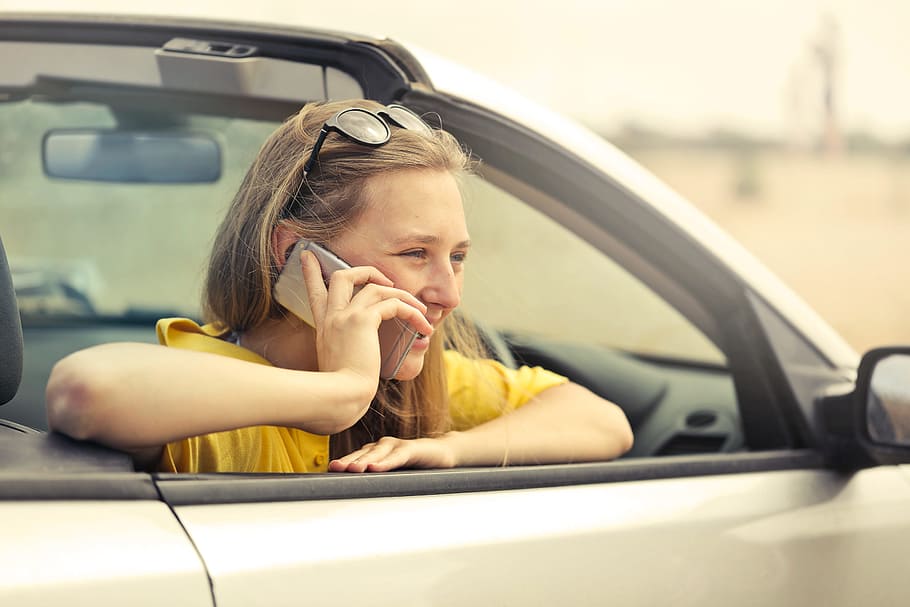 young, woman, wearing, half-sleeved, yellow, shirt, phone, sitting, car, Speaking