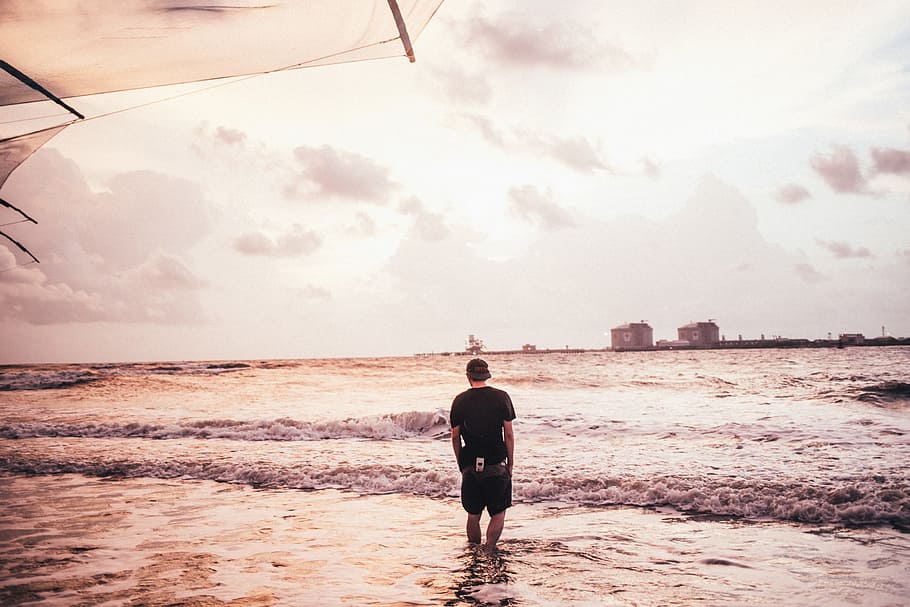 young, caucasian man wading, sea water, beach, 25-30 year old, beach life, coast, coastline, holiday, landscape