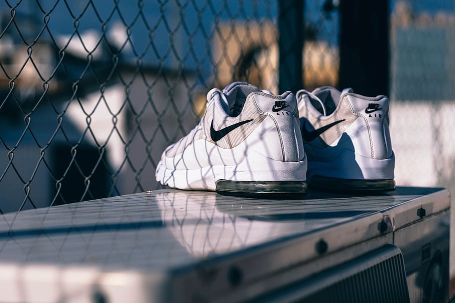 drying sneakers, fence, selective focus, day, shoe, sunlight, still life, boundary, barrier, table