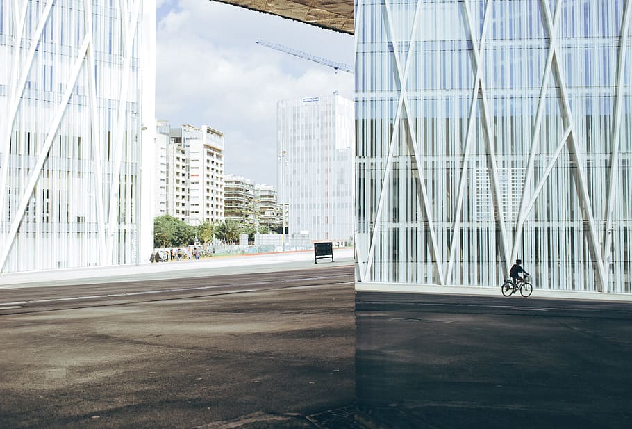 Joven, ciclista, equitación, bicicleta, frente, moderno, edificio, apartamento, arquitectura, desplazamientos