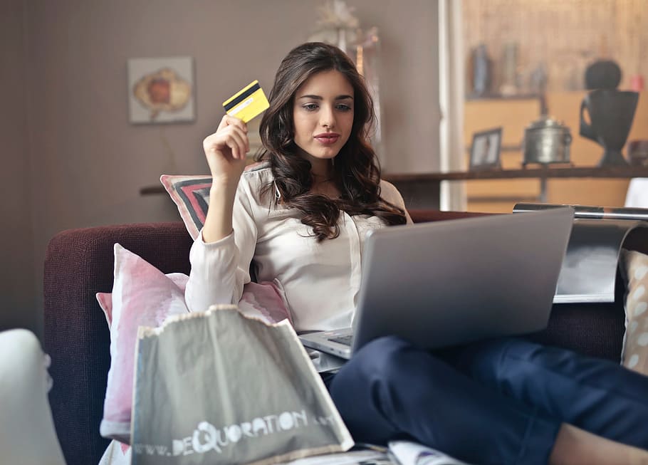 joven, mujer adulta, usando, tarjeta de crédito, tienda, en línea, tenencia, computadora portátil, regazo, 25-30 años