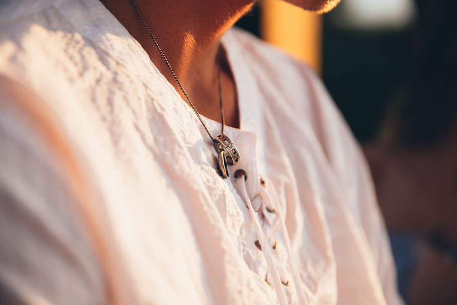 young, caucasian man, wearing, ring, neckchain, sunset, 20-25 year old, novelty, sitting, sunlight