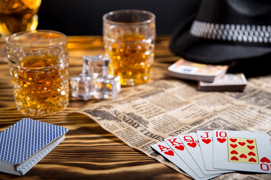 table, glass, whiskey, cards, full house, ice, hat, money, newspaper, drink