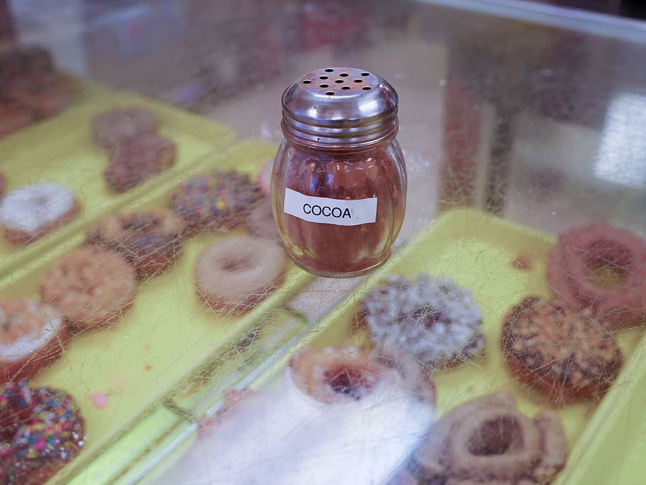 cocoa, glass shaker, sitting, counter, donut shop, shop., glass, food, dispenser, container
