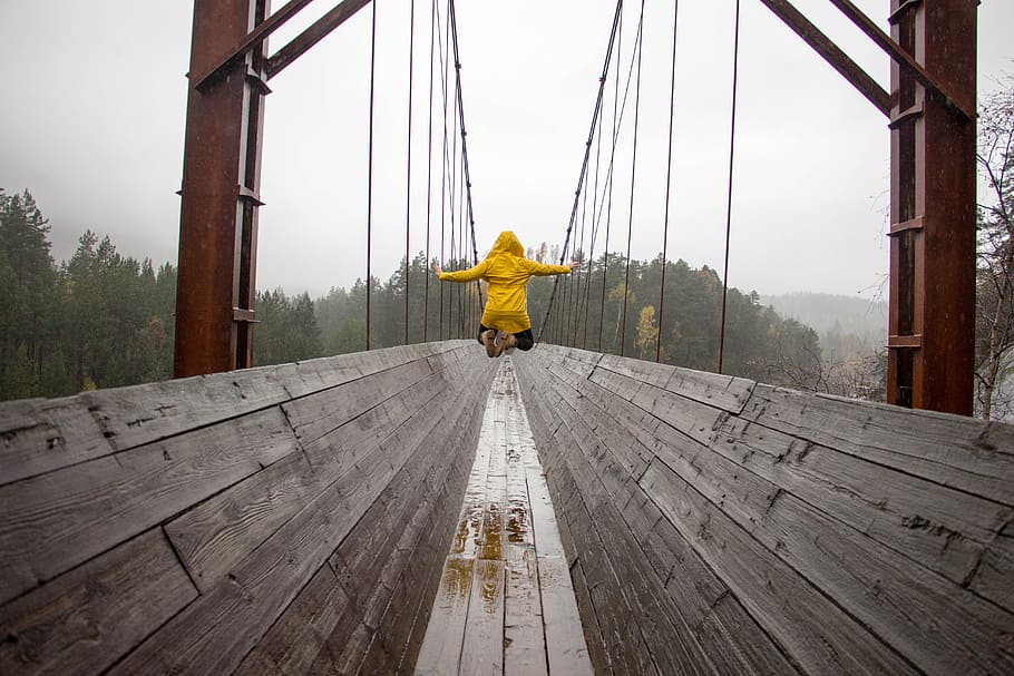 jump, rain, raincoat, bridge, trees, wood, rear view, one person, day, full length