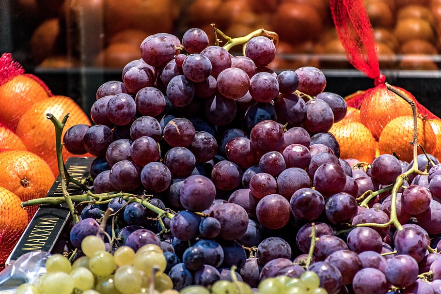 red grapes, oranges, green grapes, fruit, street vendor, sidewalk display, lush, succulent, colorful, food