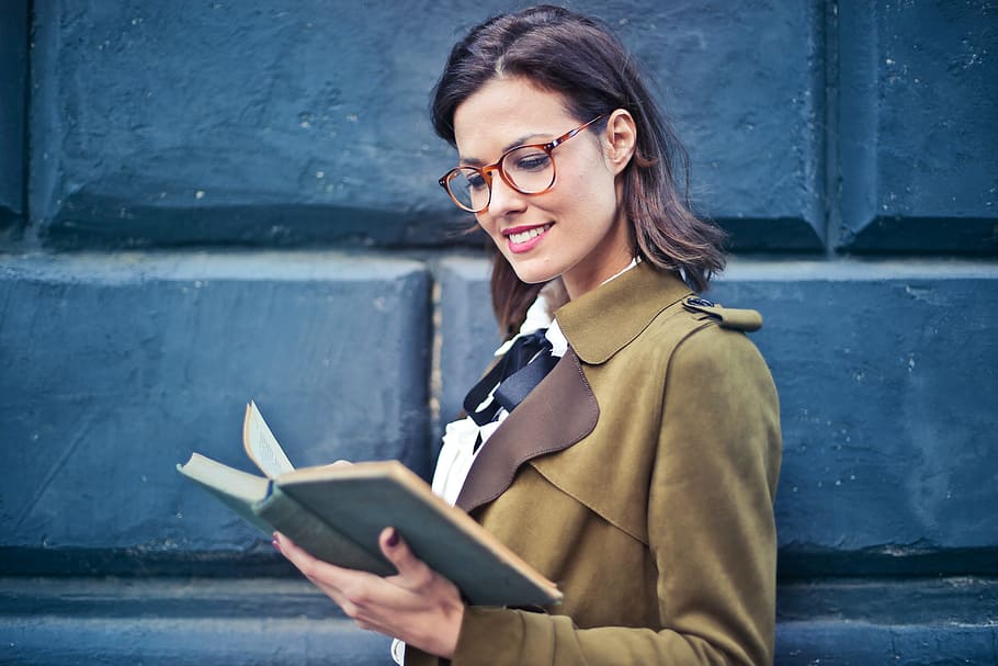 young, woman, brown, spectacles, suede pea coat reading, novel, street, 30-35 years, Beautiful, Book
