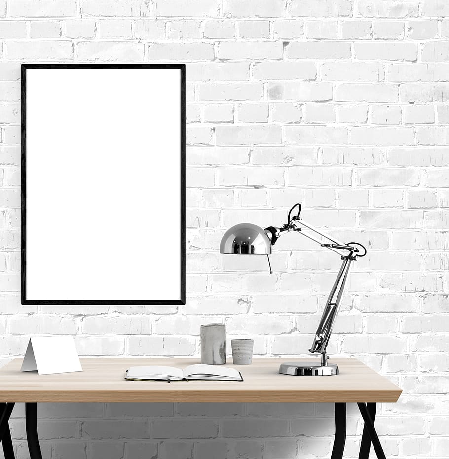 poster, frame, desk, lamp, book, wall, wall - building feature, brick wall, brick, indoors