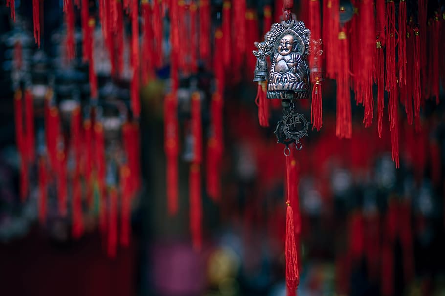 buddha souvenir, red, religion, spirituality, belief, focus on foreground, place of worship, art and craft, close-up, hanging