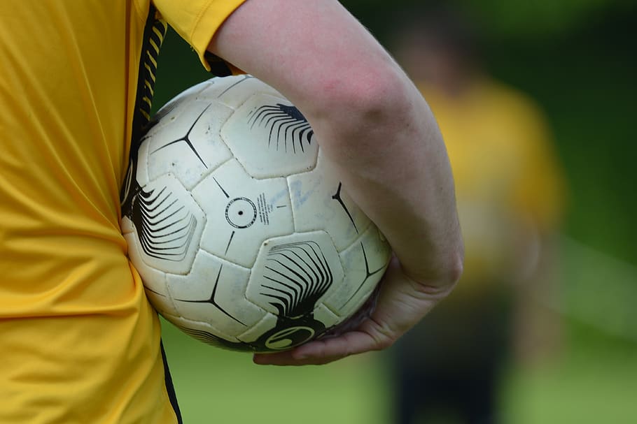 football, ball, yellow, player, match, one person, human hand, human body part, focus on foreground, hand