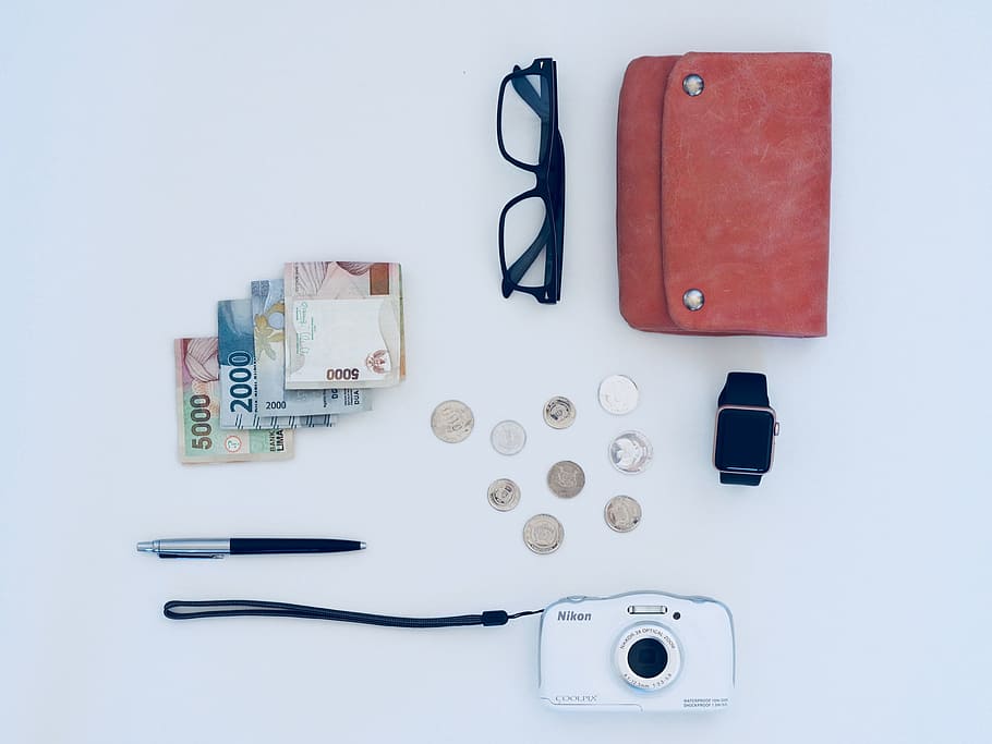 dinheiro, bolsa, óculos, câmera, relógio, fundo branco, caneta, lápis, notas, numerário