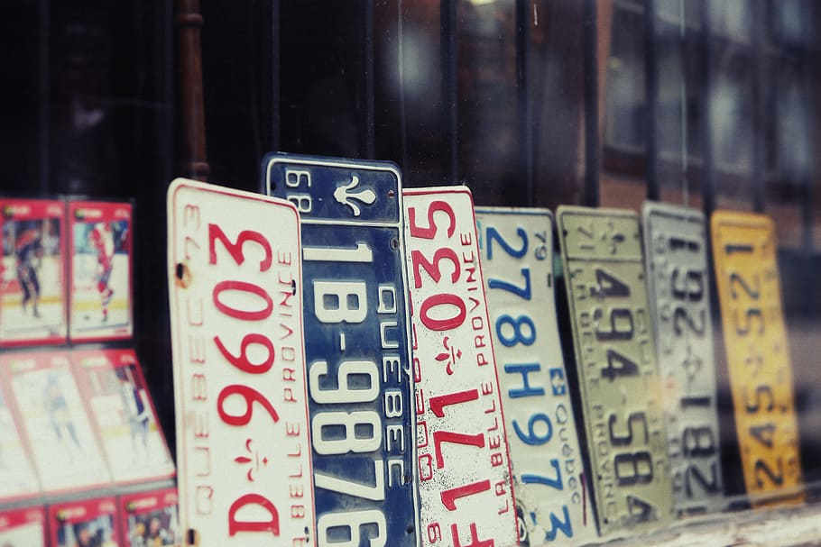license plates, text, number, close-up, communication, focus on foreground, western script, indoors, script, group of objects
