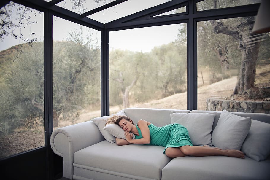 young, blonde, woman, sleeping, couch, glass house, woods, 25-30 year old, adult, architecture