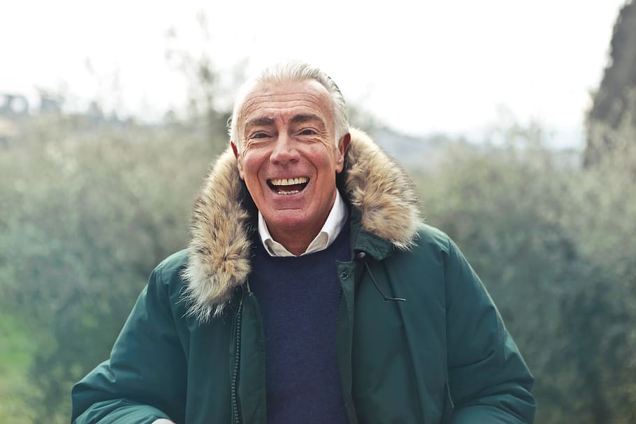 meio, idade, homem, rindo, posando, verde, falso, jaqueta com capuz de pele, 60-70 anos, jaqueta