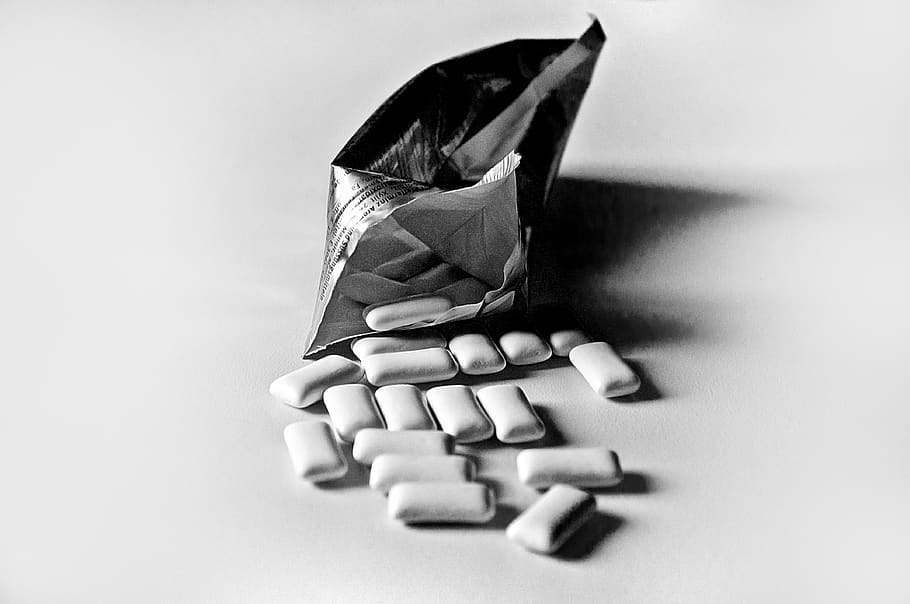 chewing gum, table, scattered, packaging, black and white, silver, shiny, retro, indoors, studio shot