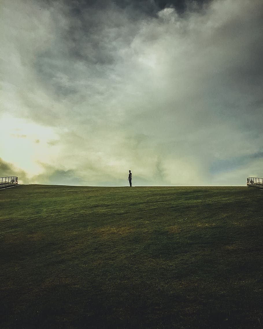 man, alone, field, calm, solitary, dramtic sky, clouds, green, male, people