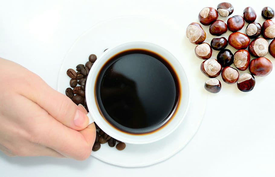 overhead, view, cup, coffee, nuts, hand, holding, mug., chestnuts, beans