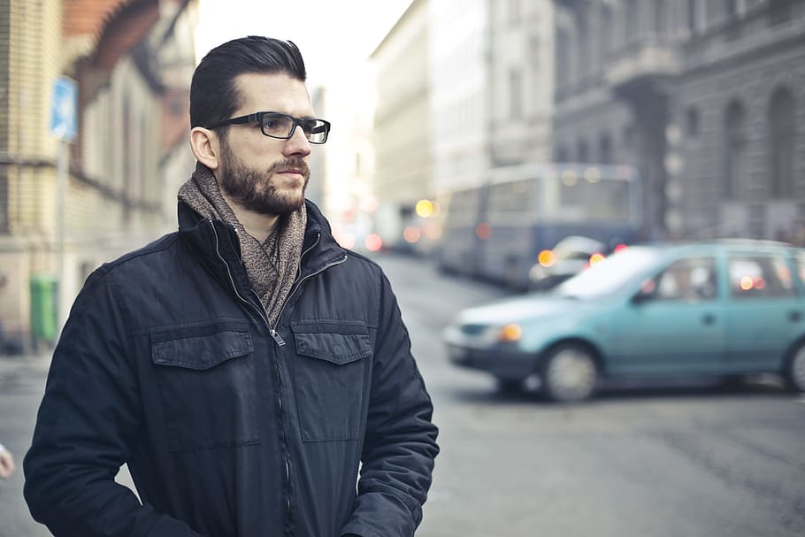 jovem, barbudo, homem, preto, jaqueta com zíper, óculos, pensando, em pé, rua, 25-30 anos