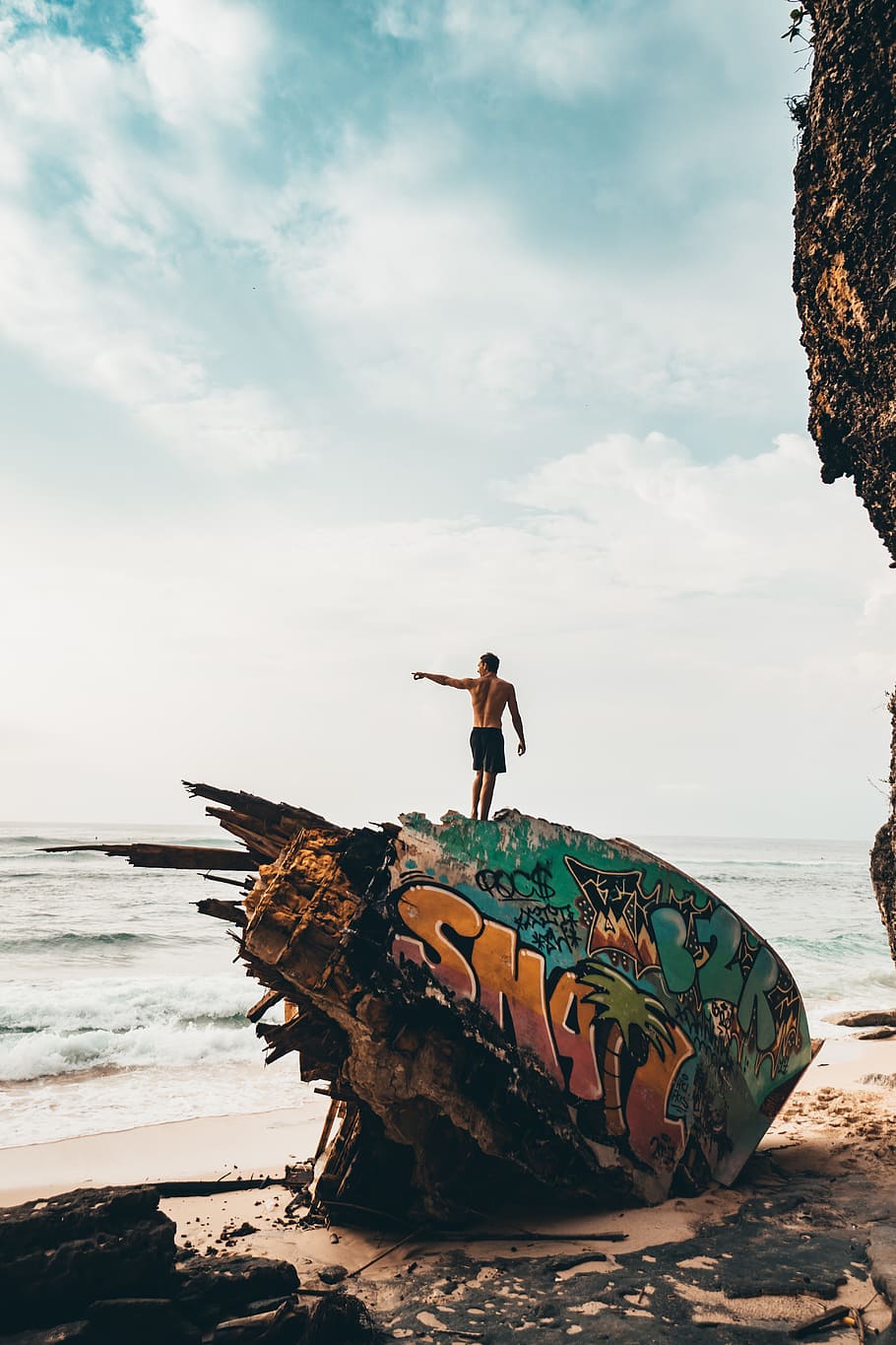 man, pointing, ocean, beach, sand, rock, grafitti, paint, art, design