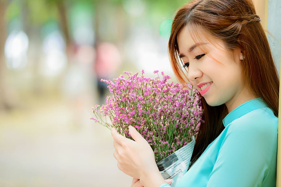 girl, long coat, smell the flowers, flower, flowering plant, plant, one person, headshot, lifestyles, beauty in nature