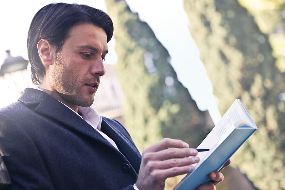 homem caucasiano, vestindo, cinza, casaco, escrevendo, caderno, 30-35 anos, livro, jardim, luz