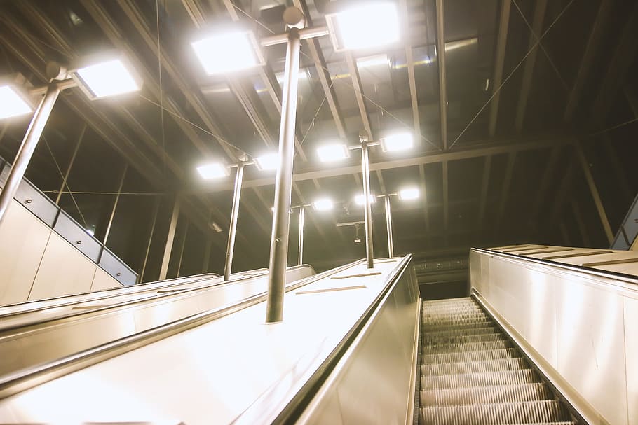 subway escalators evening, illuminated, lighting equipment, architecture, indoors, railing, escalator, staircase, built structure, modern