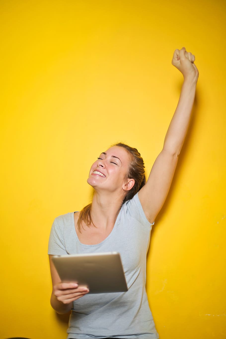 bersemangat, muda, wanita, memegang, ipad, satu, tangan, kuning, dinding, sukses memenangkan bisnis komputer tablet pengusaha wanita y