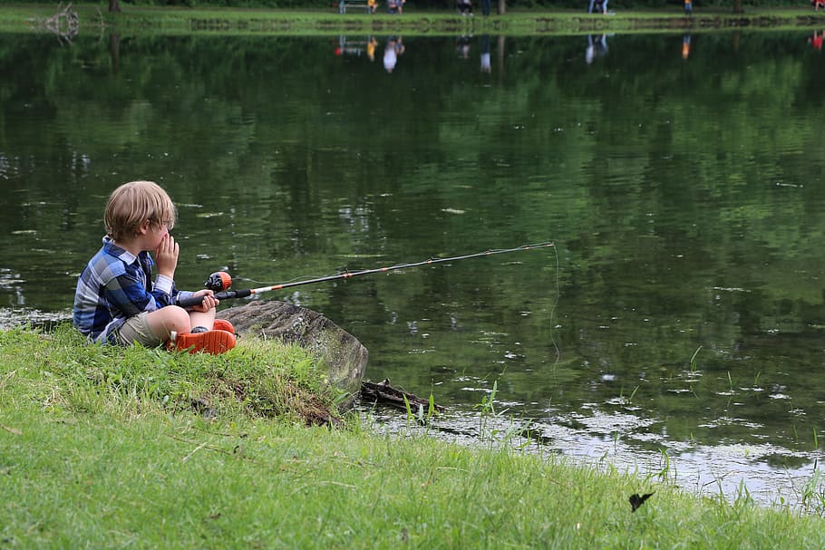 child fishing, child by pond, fishing, child in nature, childhood, sitting, child, water, real people, grass