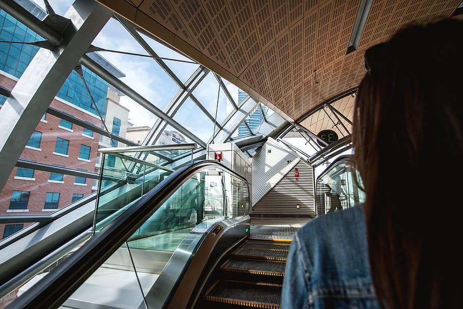 woman, escalators, metro station, architecture, transportation, built structure, one person, city, mode of transportation, indoors
