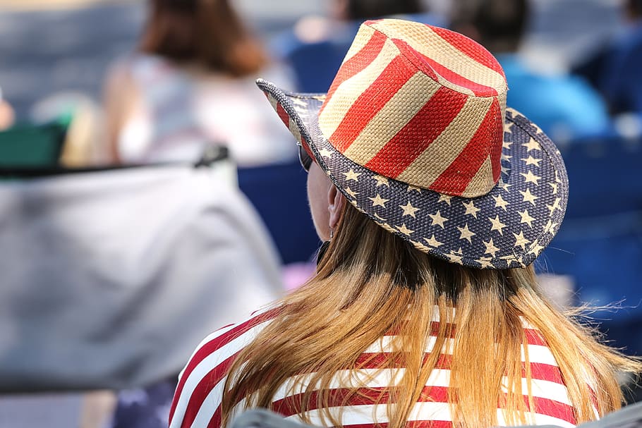 belakang, melihat, duduk, wanita, mengenakan, topi bendera Amerika, parade., 4 Juli, bendera Amerika, perayaan