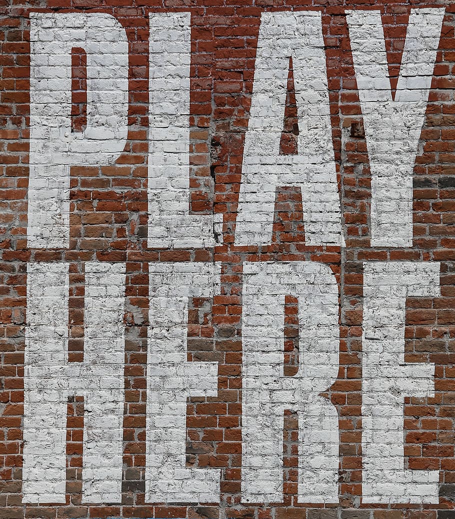 large, painted, letters, say, play, white, old, red, brick wall, wall.